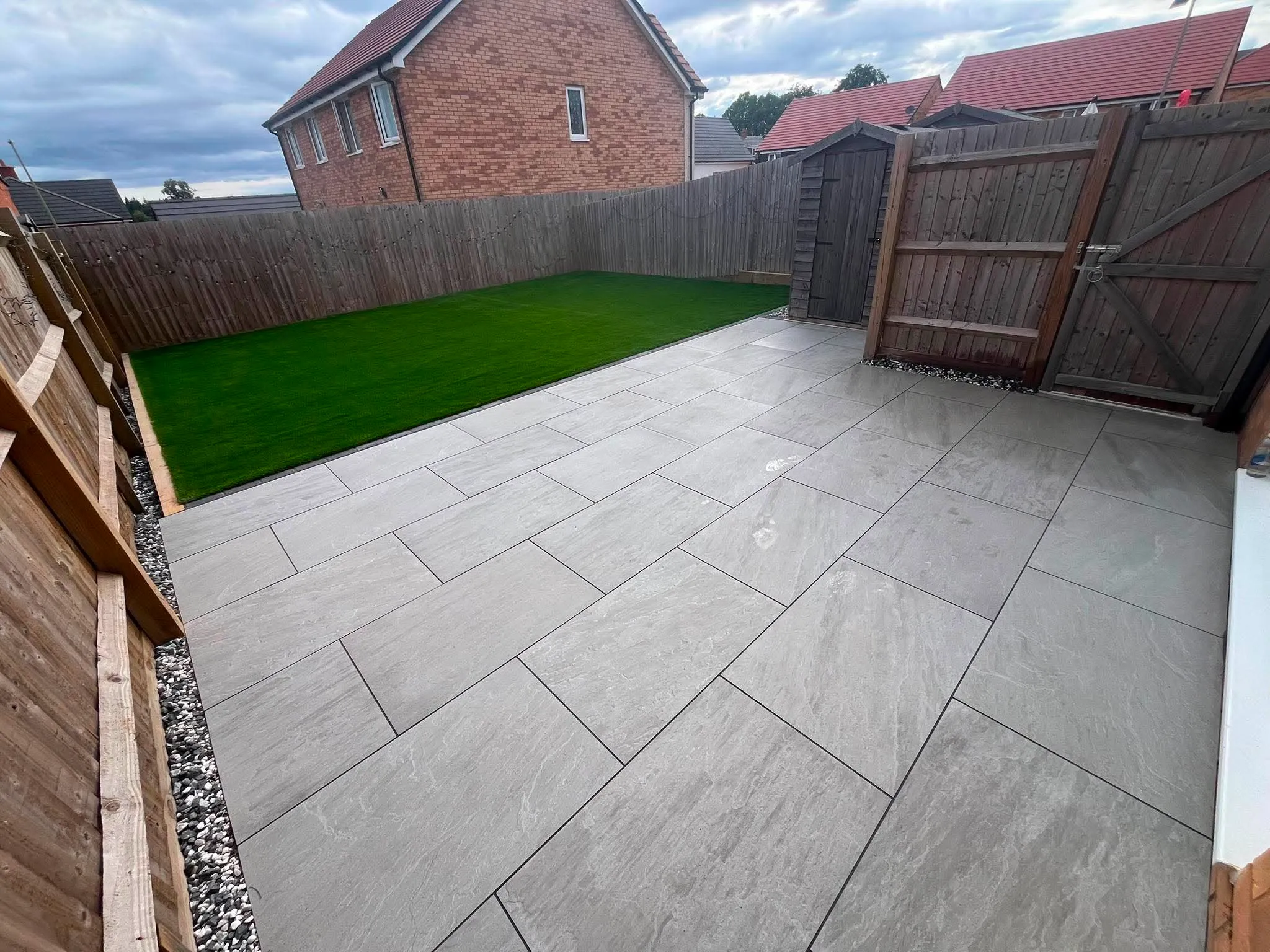 Grey porcelain patio with artificial grass lawn