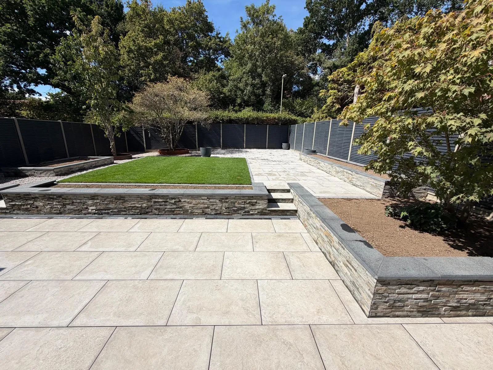 Multi-level patio with stone raised flower beds
